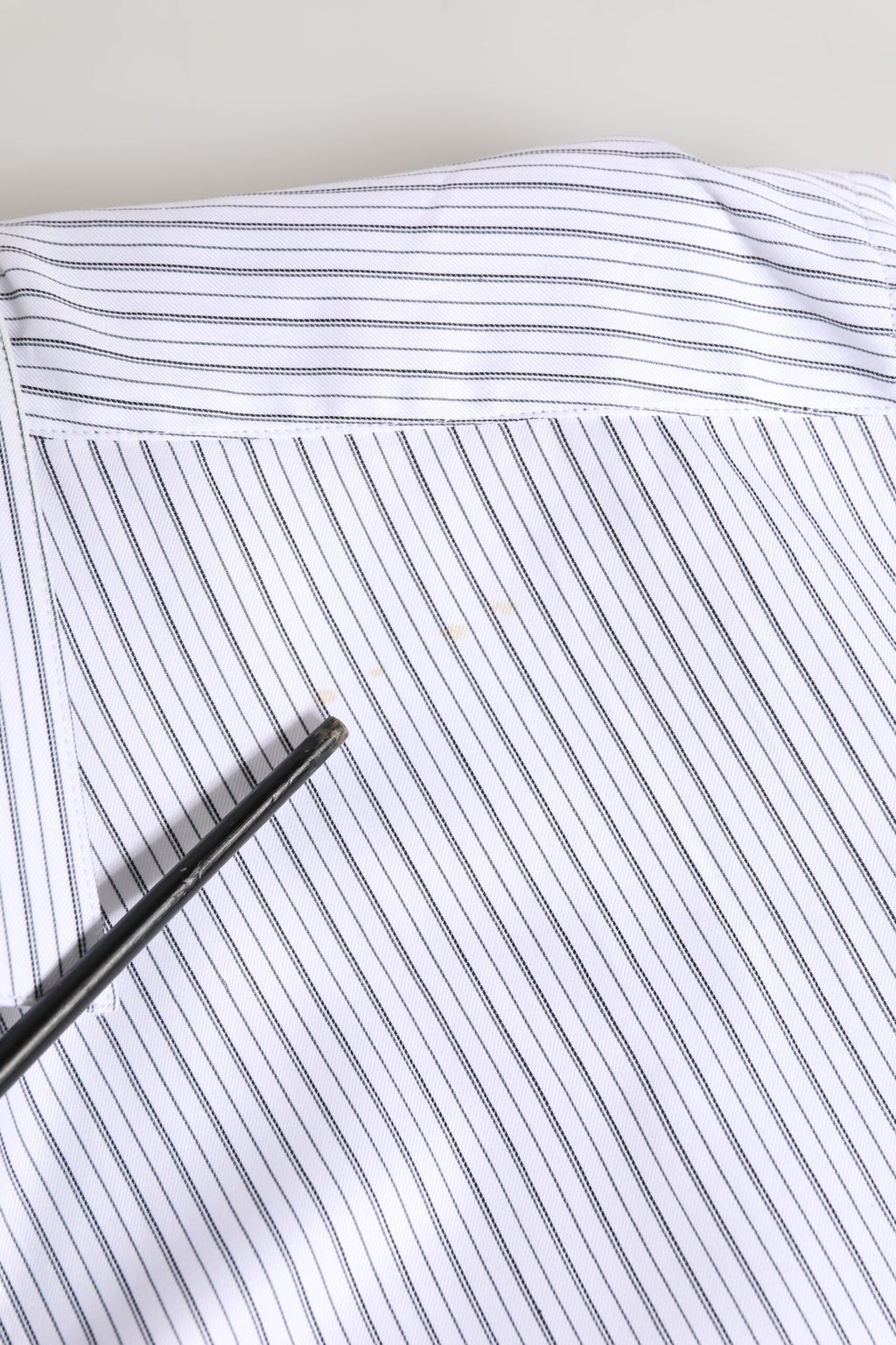 Chemise Dolce & Gabbana à rayures blanches à manches longues avec détails dorés, élégante et sophistiquée.