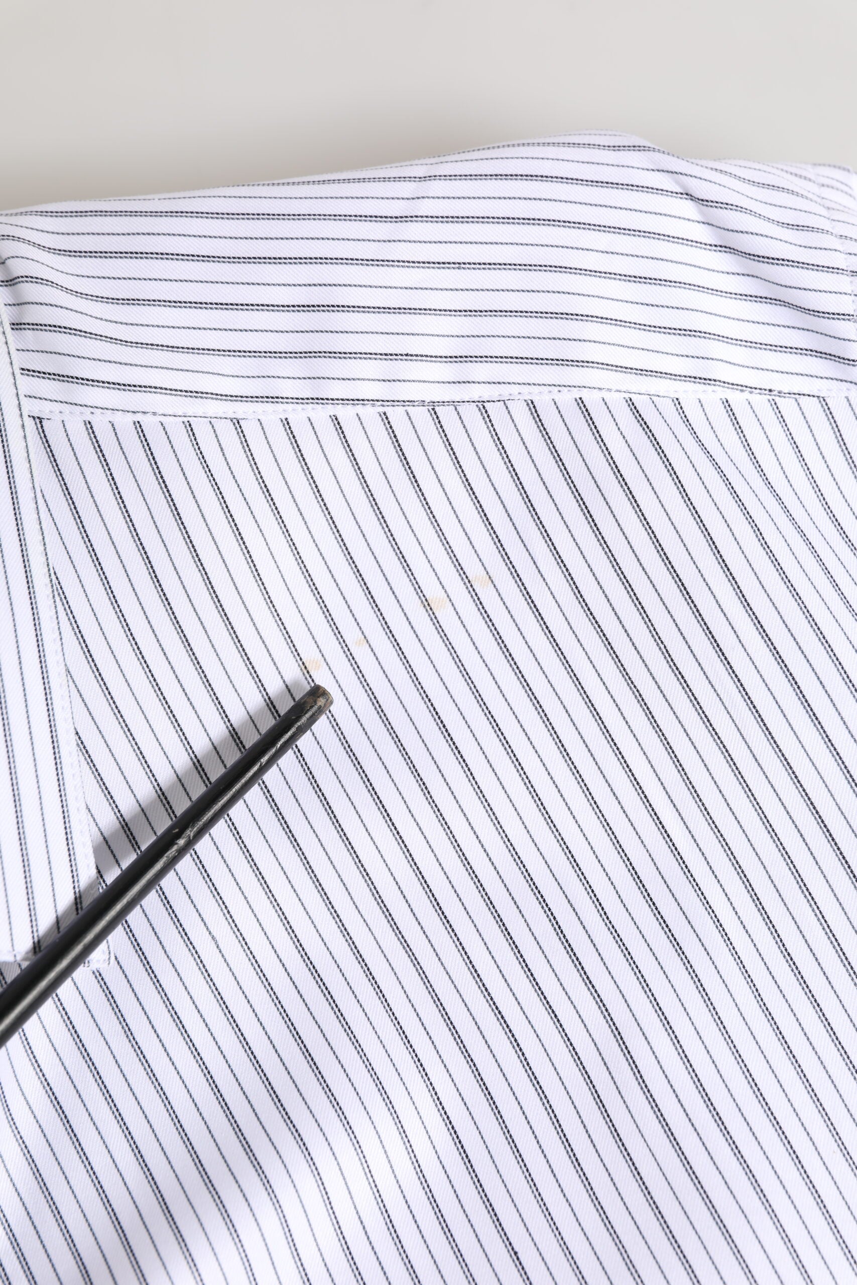 Chemise Dolce & Gabbana à rayures blanches à manches longues avec détails dorés, élégante et sophistiquée.