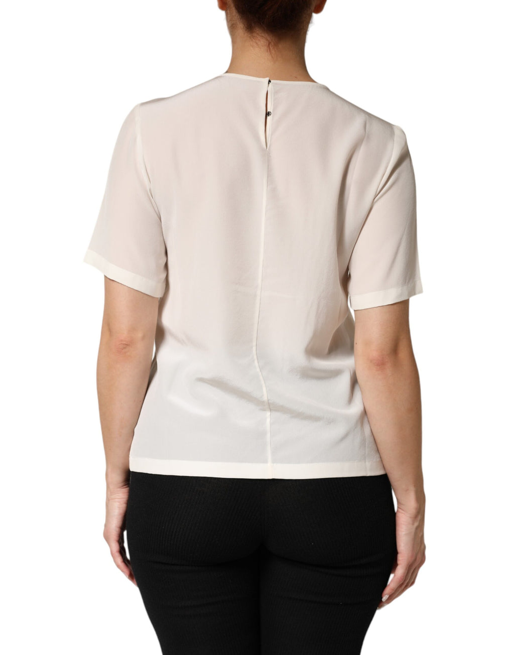 Top Dolce & Gabbana en soie crème à manches courtes avec silhouette élégante et détails raffinés, porté sur un mannequin.