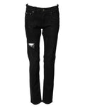 Jeans skinny en denim noir déchiré pour homme de Dolce & Gabbana, coupe ajustée et détails usés visibles.