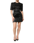 Robe courte noire Dolce & Gabbana à manches courtes avec embellissements, coupe ajustée et élégante, portée en soirée.