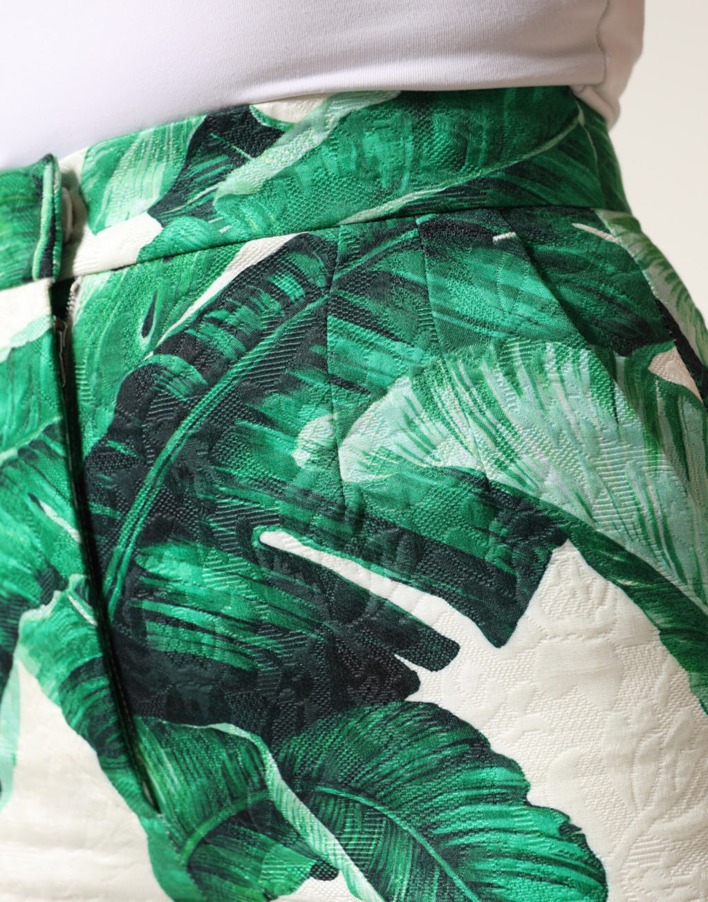 Pantalon taille haute Dolce & Gabbana blanc et vert avec motif de feuilles, mode élégante et sophistiquée.