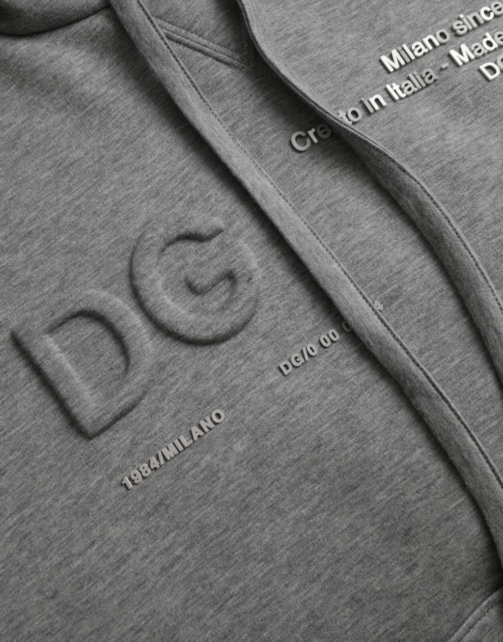 Sweat à capuche en coton gris Dolce & Gabbana avec logo, style décontracté, porté sur un mannequin.