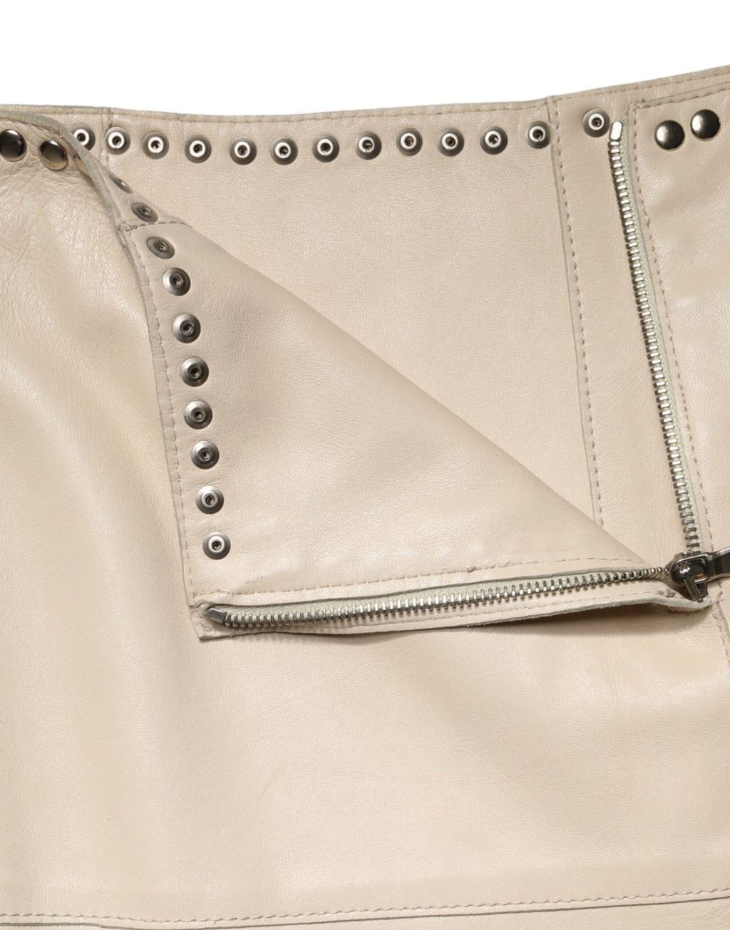 Jupe courte en cuir beige Dolce & Gabbana avec clous, taille mi-haute, style élégant et tendance.