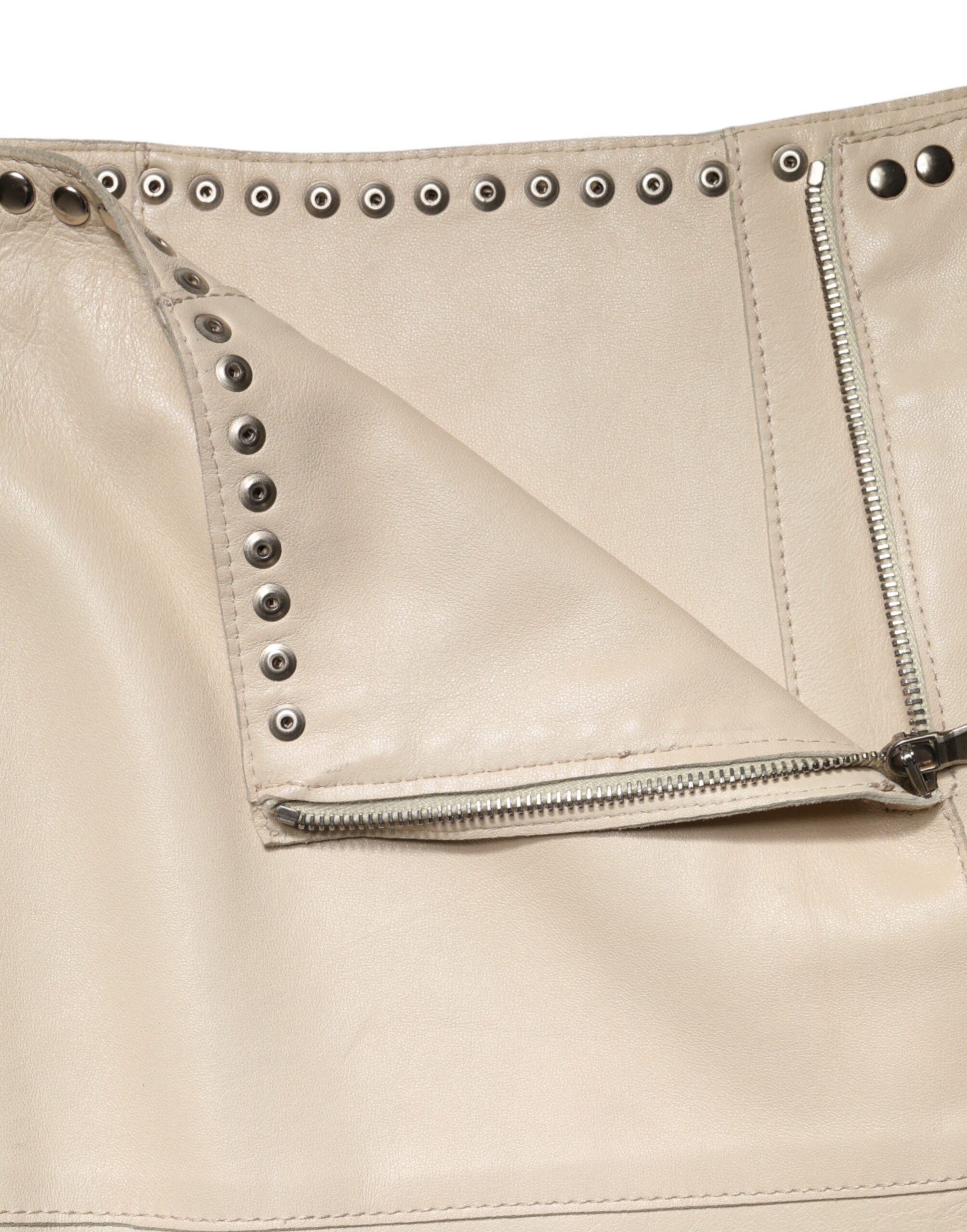 Jupe courte en cuir beige Dolce & Gabbana avec clous, taille mi-haute, style élégant et tendance.