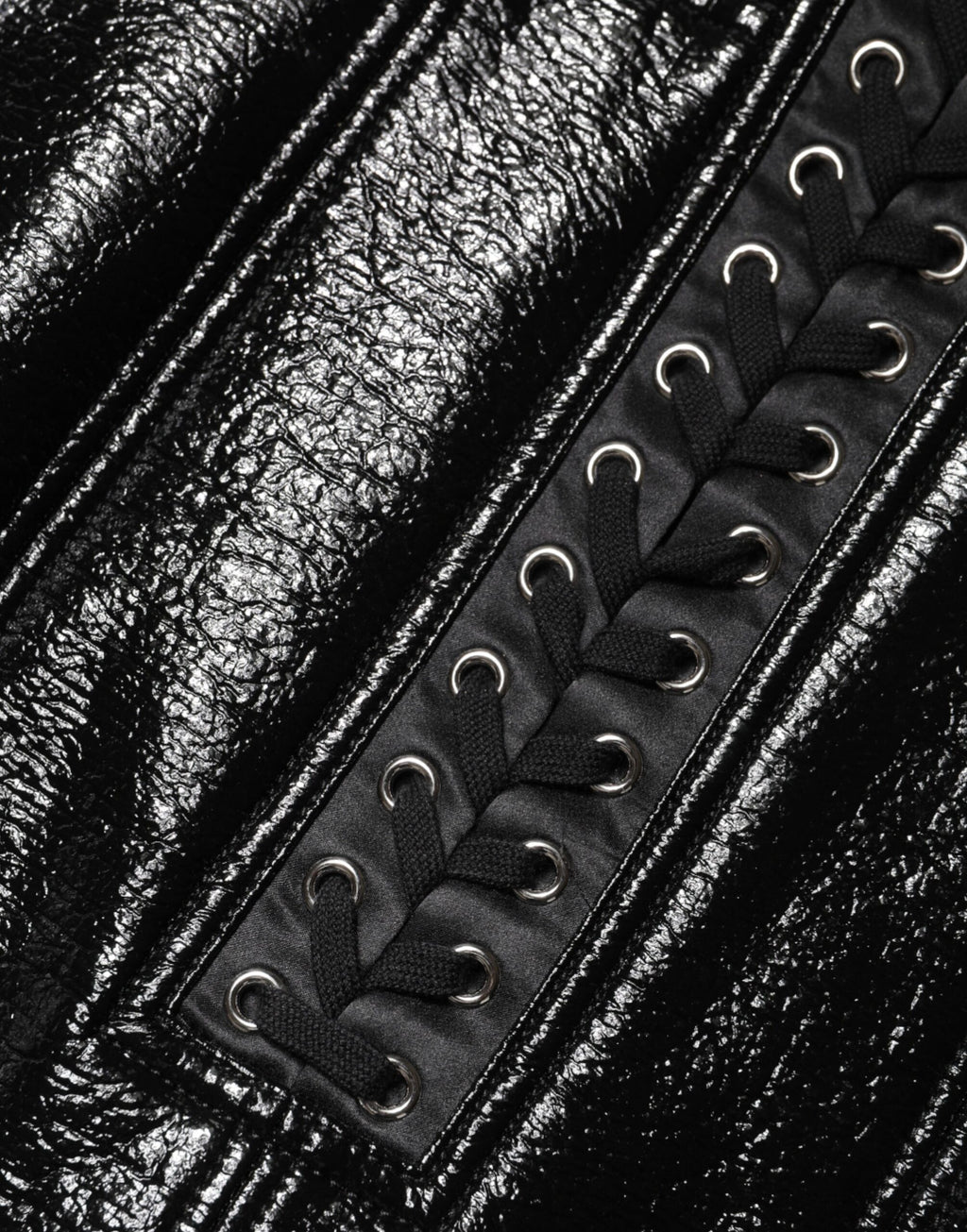 Mini jupe noire en nylon de Dolce & Gabbana avec détails œillets et finition laquée, style tendance et élégante.