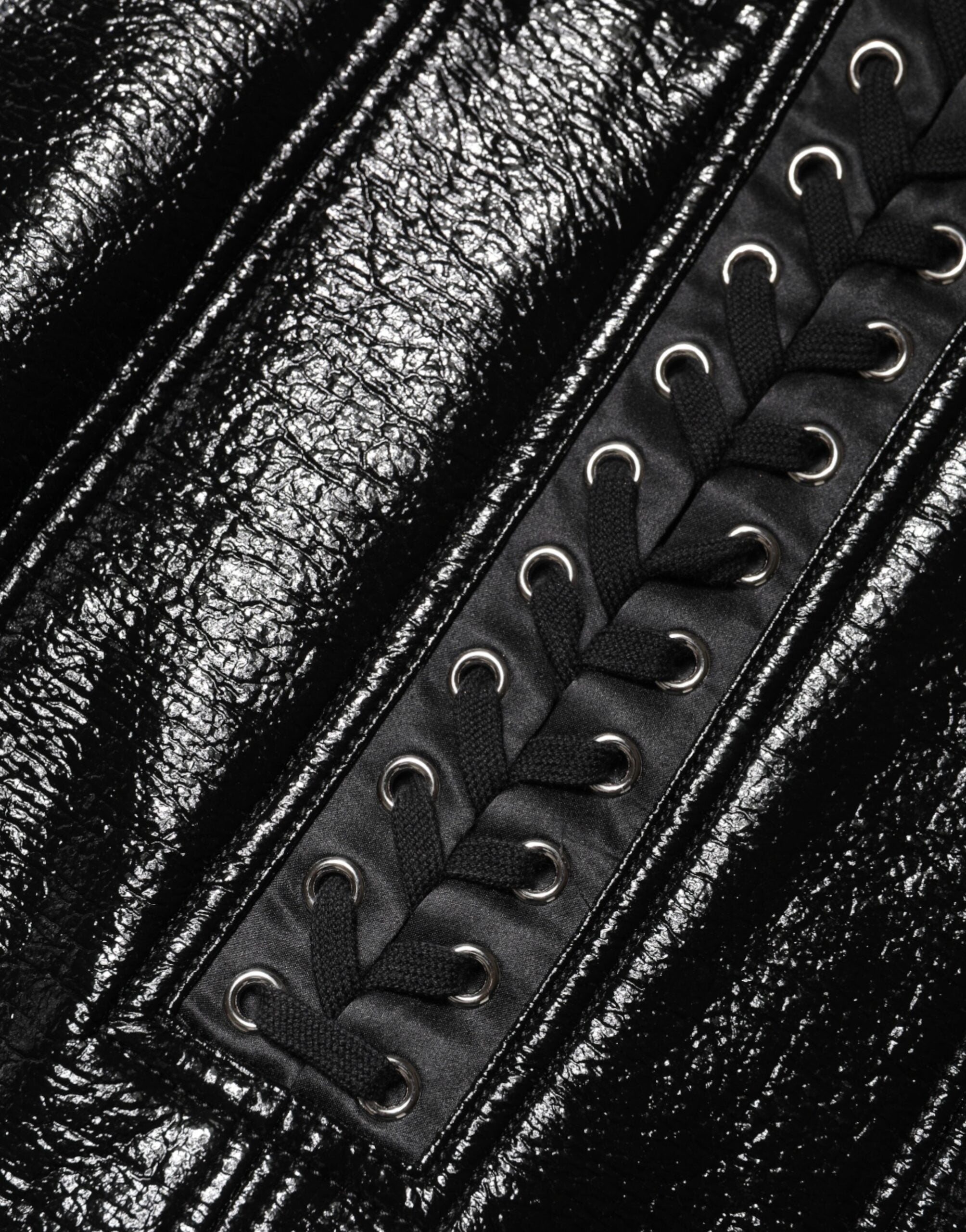 Mini jupe noire en nylon de Dolce & Gabbana avec détails œillets et finition laquée, style tendance et élégante.