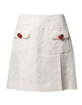 Jupe courte blanche en brocart floral Dolce & Gabbana à taille haute, élégante et sophistiquée.