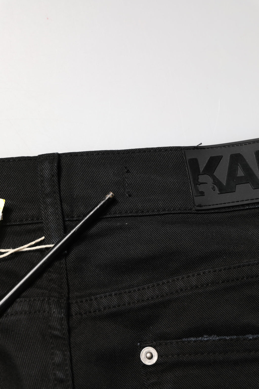 Jeans skinny noirs pour homme Karl Lagerfeld, déchirés et tachetés, en denim usé avec style.