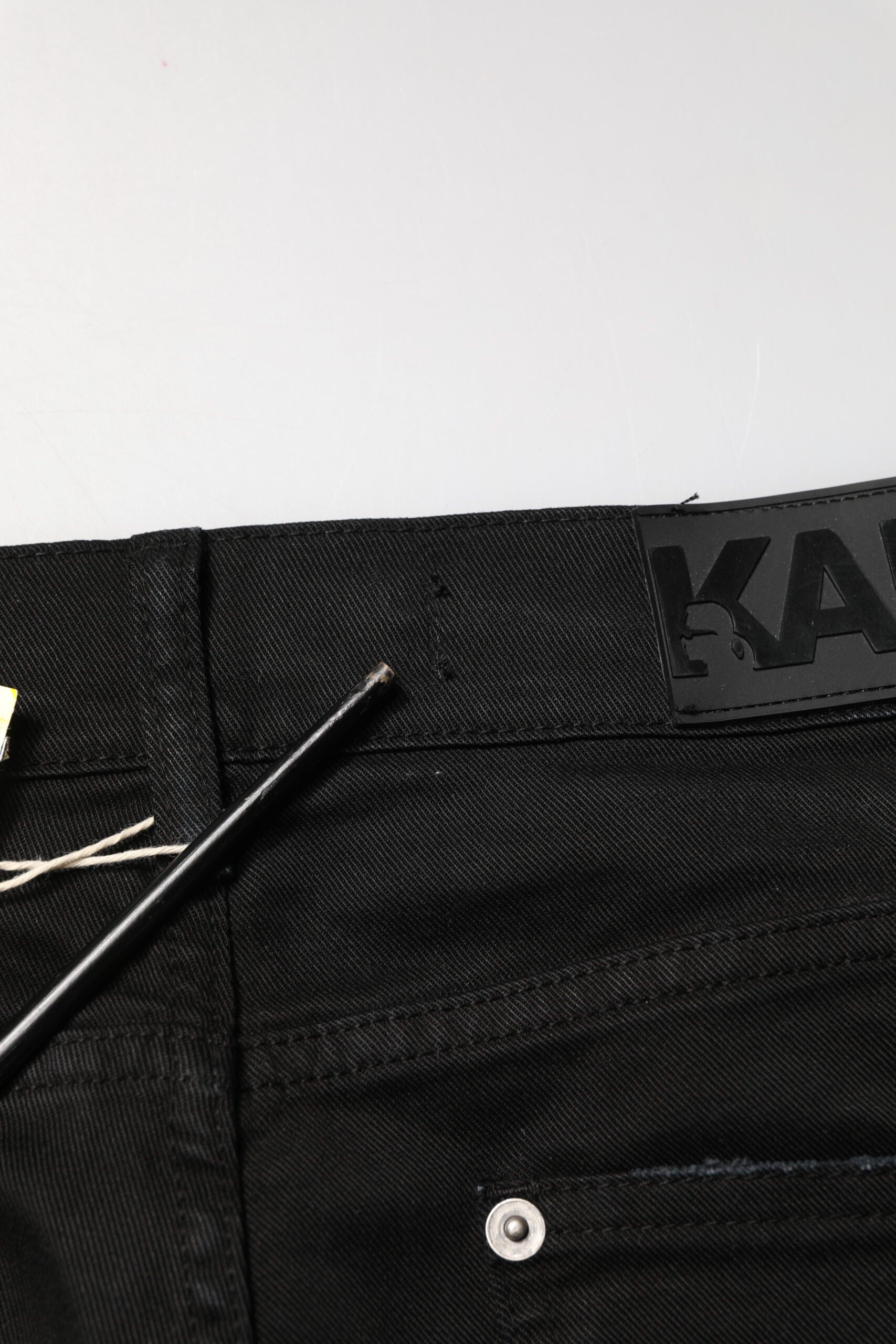 Jeans skinny noirs pour homme Karl Lagerfeld, déchirés et tachetés, en denim usé avec style.