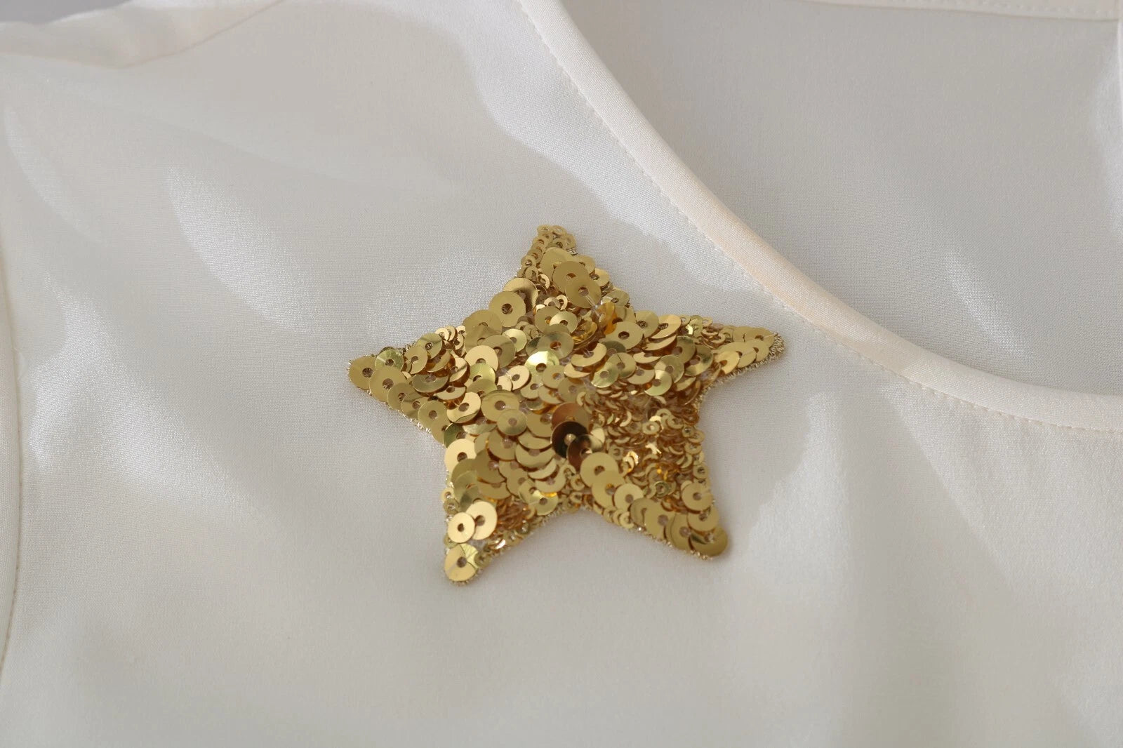 Top blanc Dolce & Gabbana avec sequins et cristaux, style féerique et orné de détails scintillants.