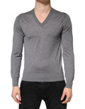 Pull en cachemire gris Dolce & Gabbana pour homme avec col en V, aspect doux et élégant, porté sur un fond neutre.