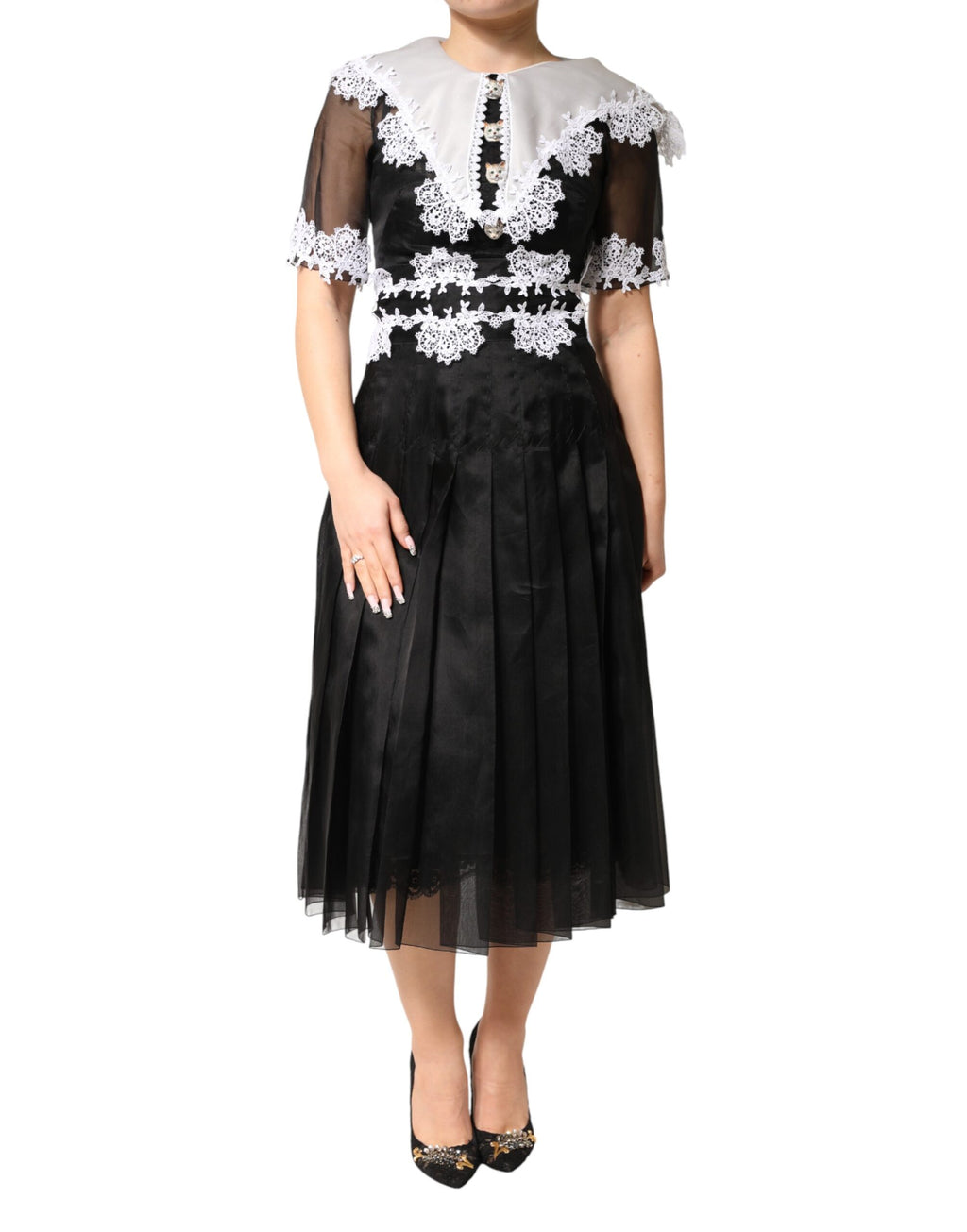 Robe midi en soie noire et blanche avec dentelle en macramé, créée par Dolce & Gabbana, portée dans une tenue élégante.