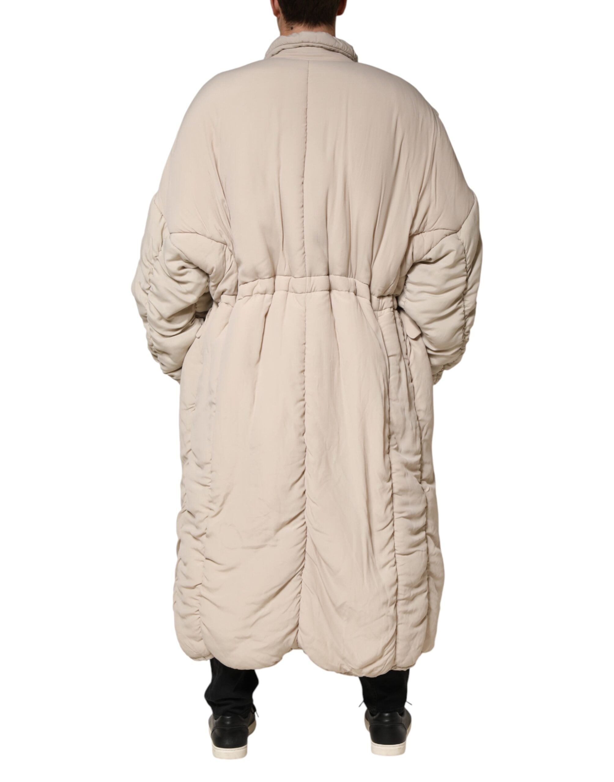 Manteau long beige Dolce & Gabbana en duvet avec col montant et détails de couture élégants.