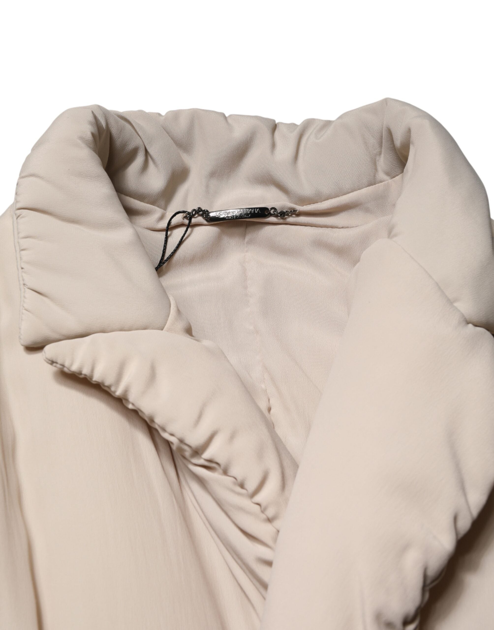 Imperméable long beige Dolce & Gabbana avec col rembourré, coupe élégante et détails sophistiqués.