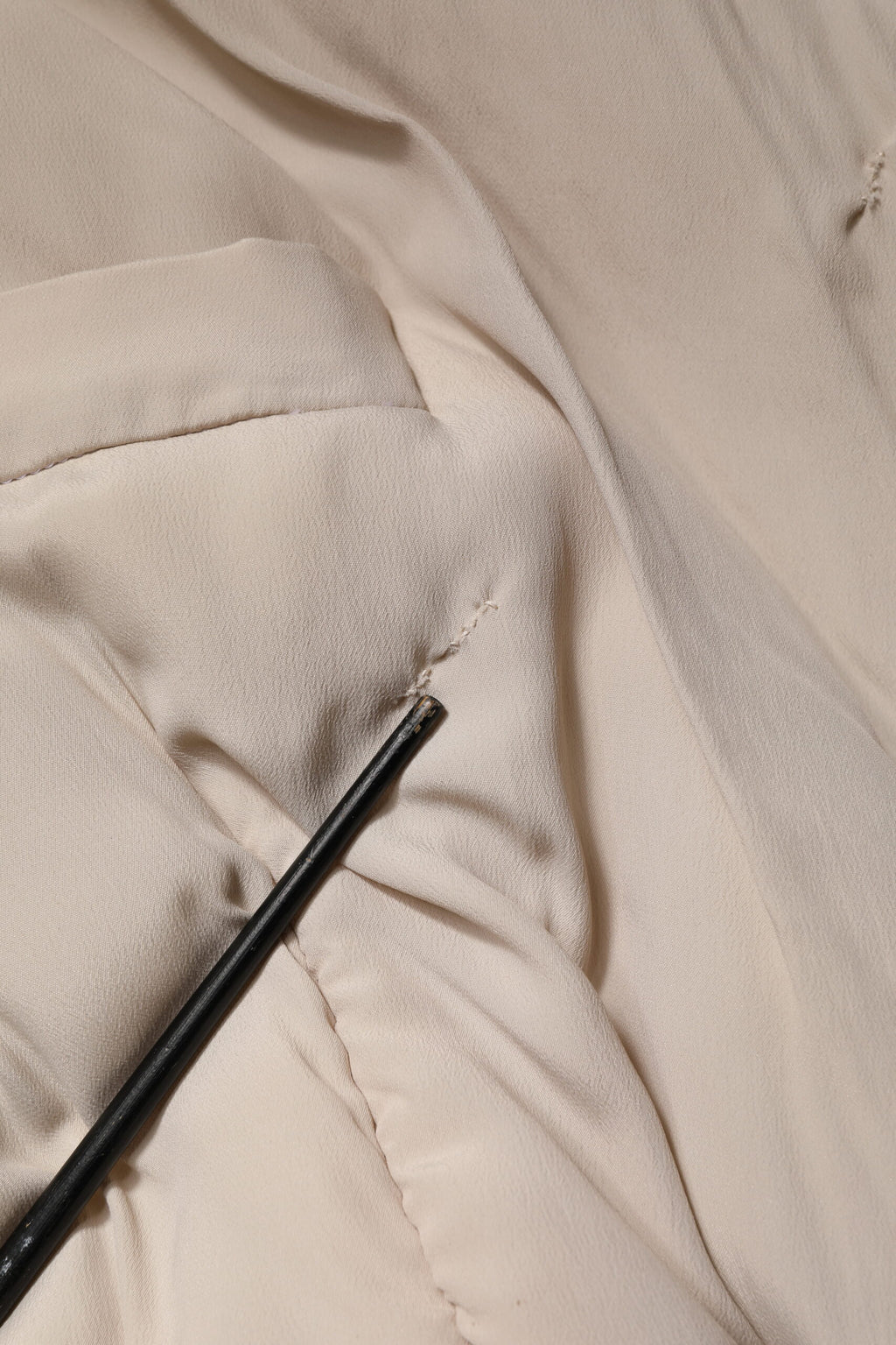 Manteau long beige Dolce & Gabbana à col rembourré, coupe trench, style élégant avec ceinture et détails sophistiqués.