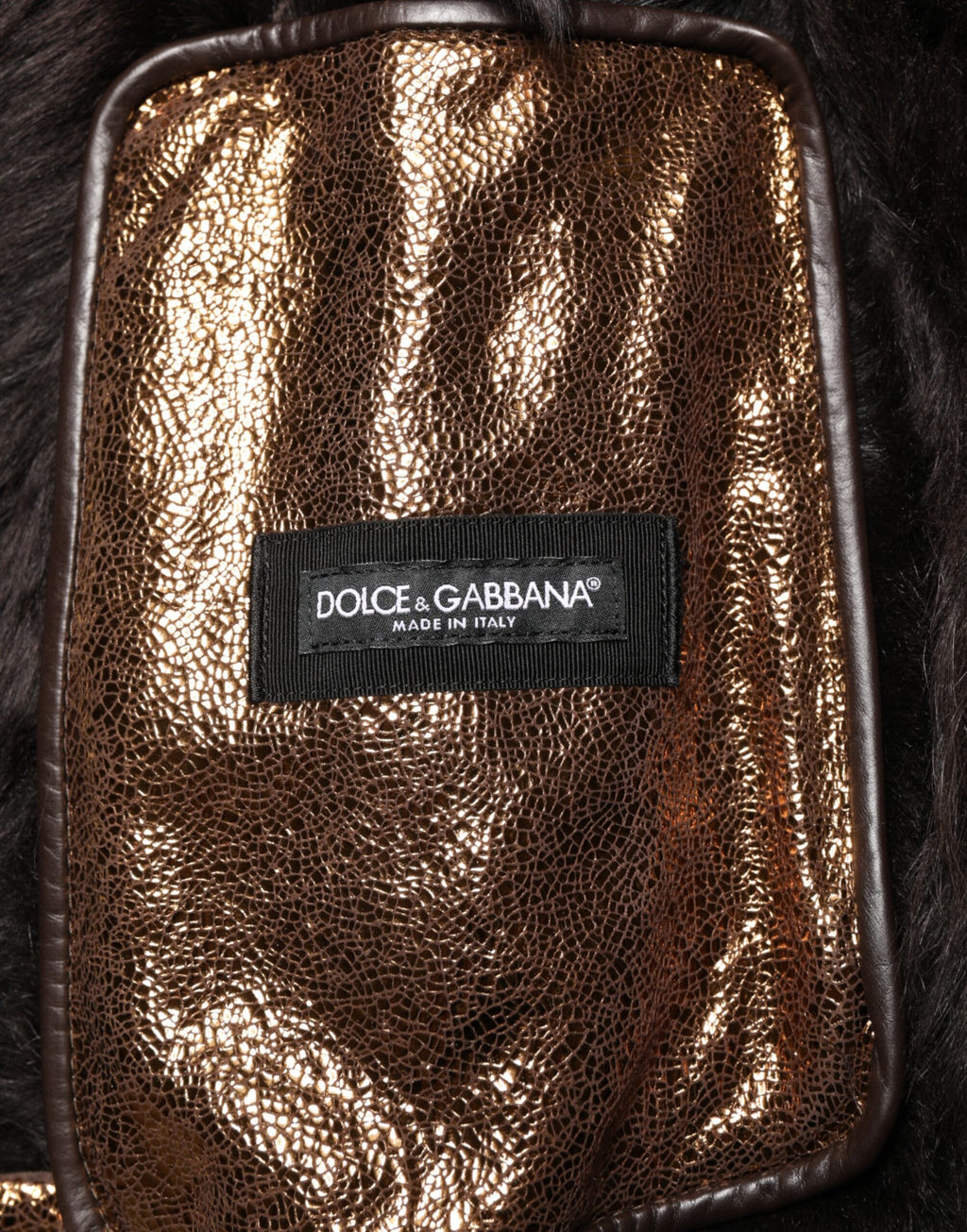 Veste biker en cuir bronze avec fourrure complète de Dolce & Gabbana pour homme, fermée par zip, style élégant et audacieux.