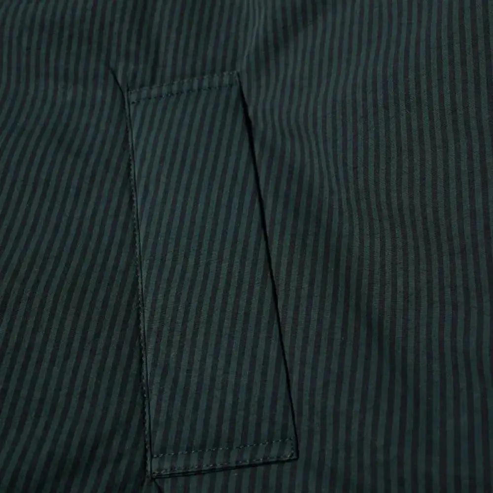 Poche en tissu rayé vertical vert foncé et noir avec couture soignée sur veste longue en coton noir balenciaga