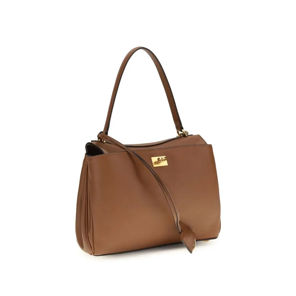 Un sac épaule balenciaga bos taurus en cuir de veau marron avec une plaque logo dorée et une bandoulière assortie
