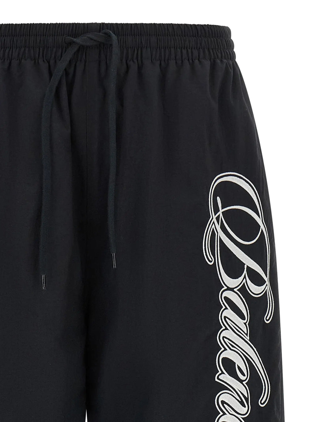 Shorts athlétiques noirs balenciaga en polyamide avec logo blanc cursif sur le côté et taille élastique