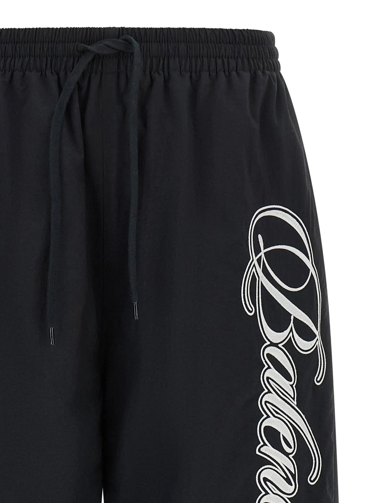 Shorts athlétiques noirs balenciaga en polyamide avec logo blanc cursif sur le côté et taille élastique