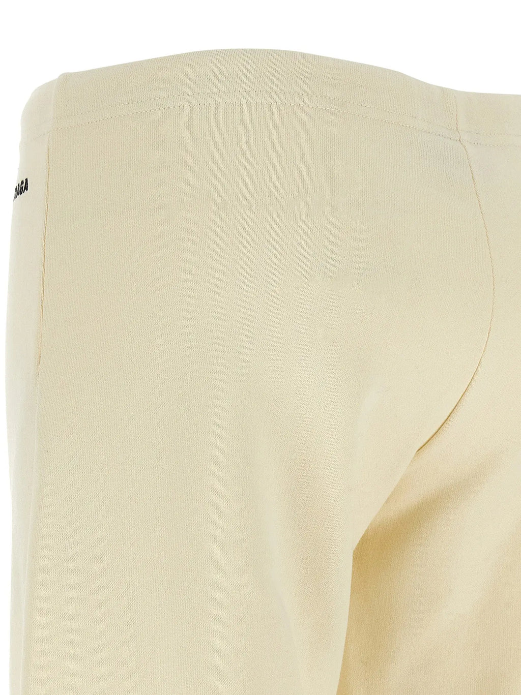 Pantalon évasé blanc en coton balenciaga avec taille côtelée crème et logo noir discret sur la couture côté