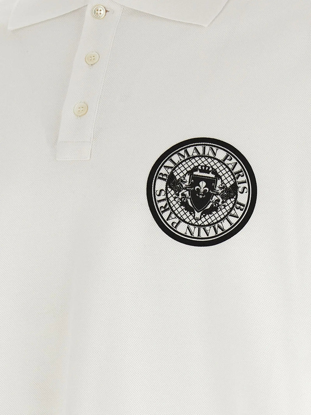 White balmain paris polo shirt in cotton featuring a black circular logo with brand name and crest embroidered on the chest