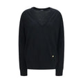 Pull-over balmain noir en laine avec col en v, tricot texturé subtil et bouton doré sur le côté inférieur droit