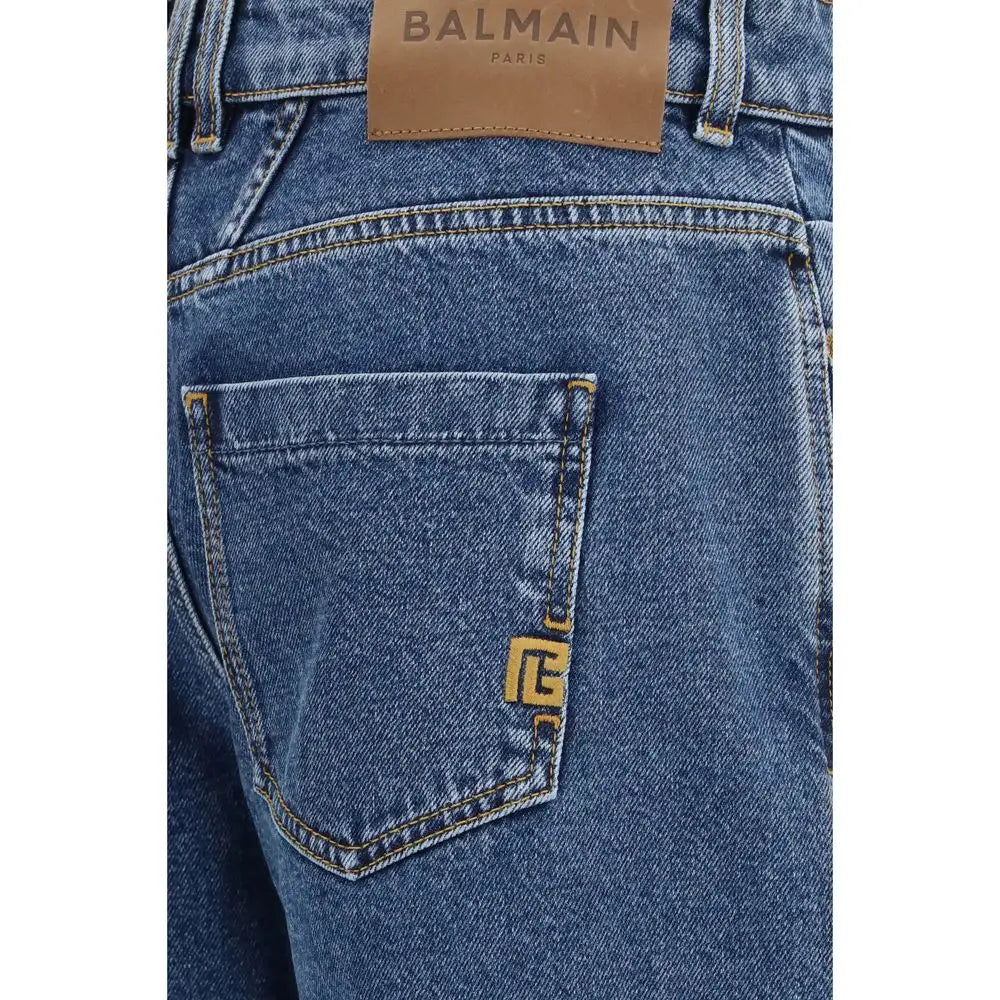 Vue arrière de jeans en denim bleu balmain en coton avec patch en cuir marron et logo doré sur la poche arrière