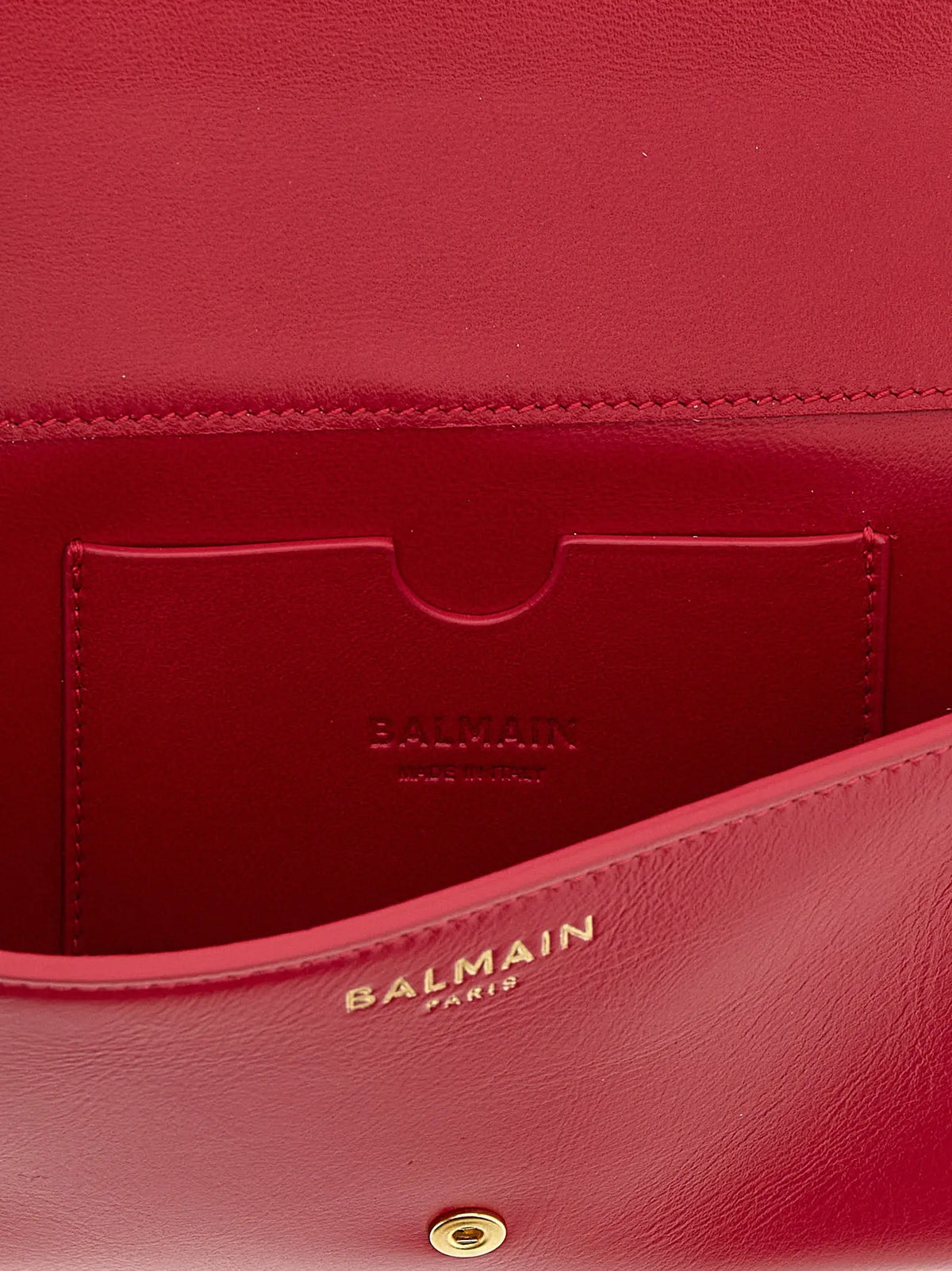 Un porte-cartes balmain fuchsia en cuir de veau rouge vif avec une finition lisse et des détails dorés