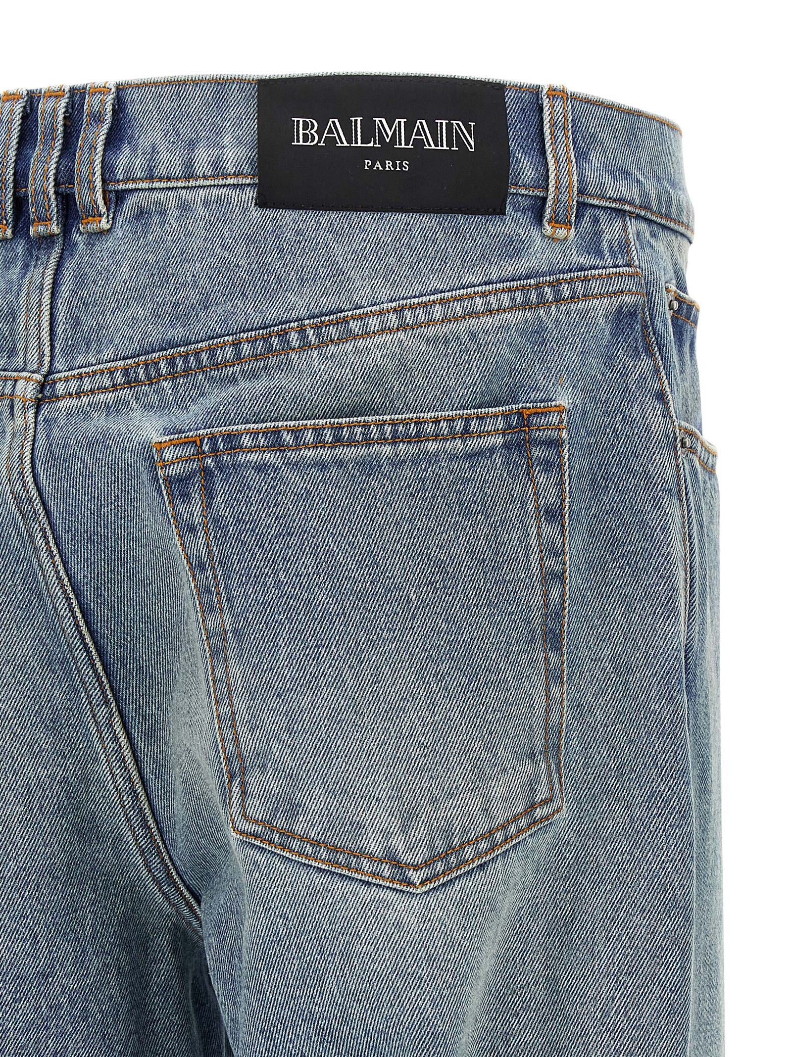 Jeans en denim en coton bleu Balmain, coupe classique avec détails modernes, visibles sur cette image.