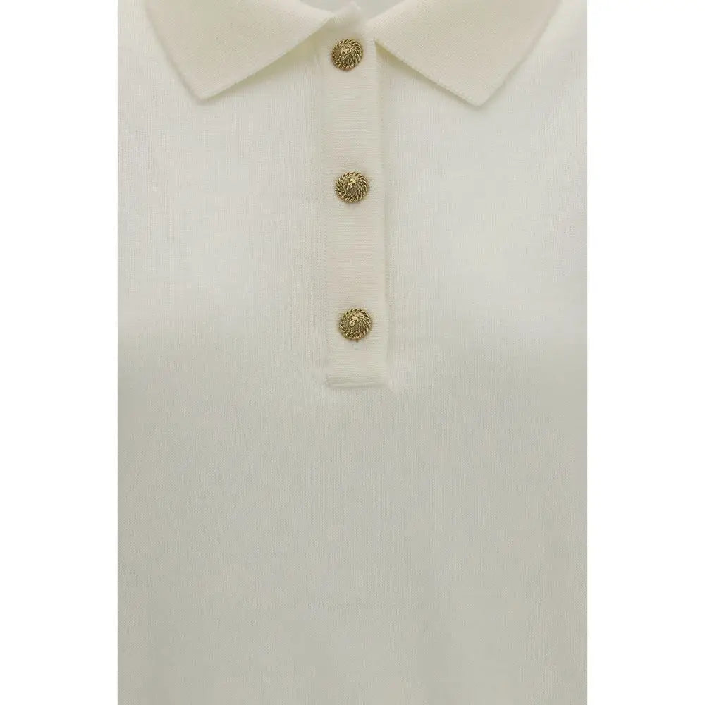 Polo balmain blanc en laine avec trois boutons ornés dorés sur fond crème