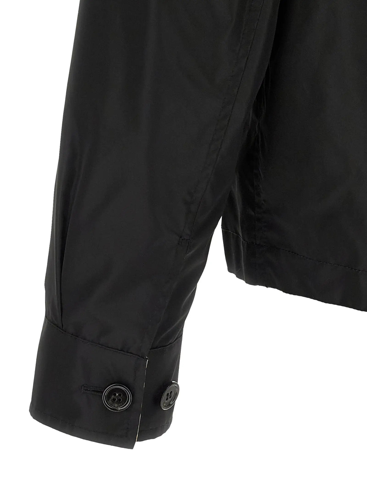 Bouton noir sur le poignet d’une veste burberry en coque polyamide noire ajustée