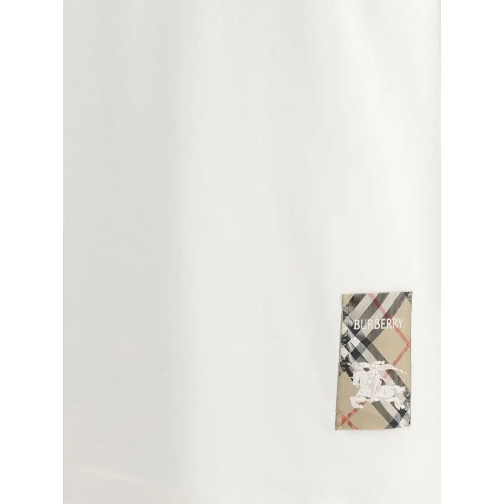 Étiquette burberry beige noir et rouge à carreaux avec logo cheval et cavalier brodé blanche sur t-shirt coton blanc