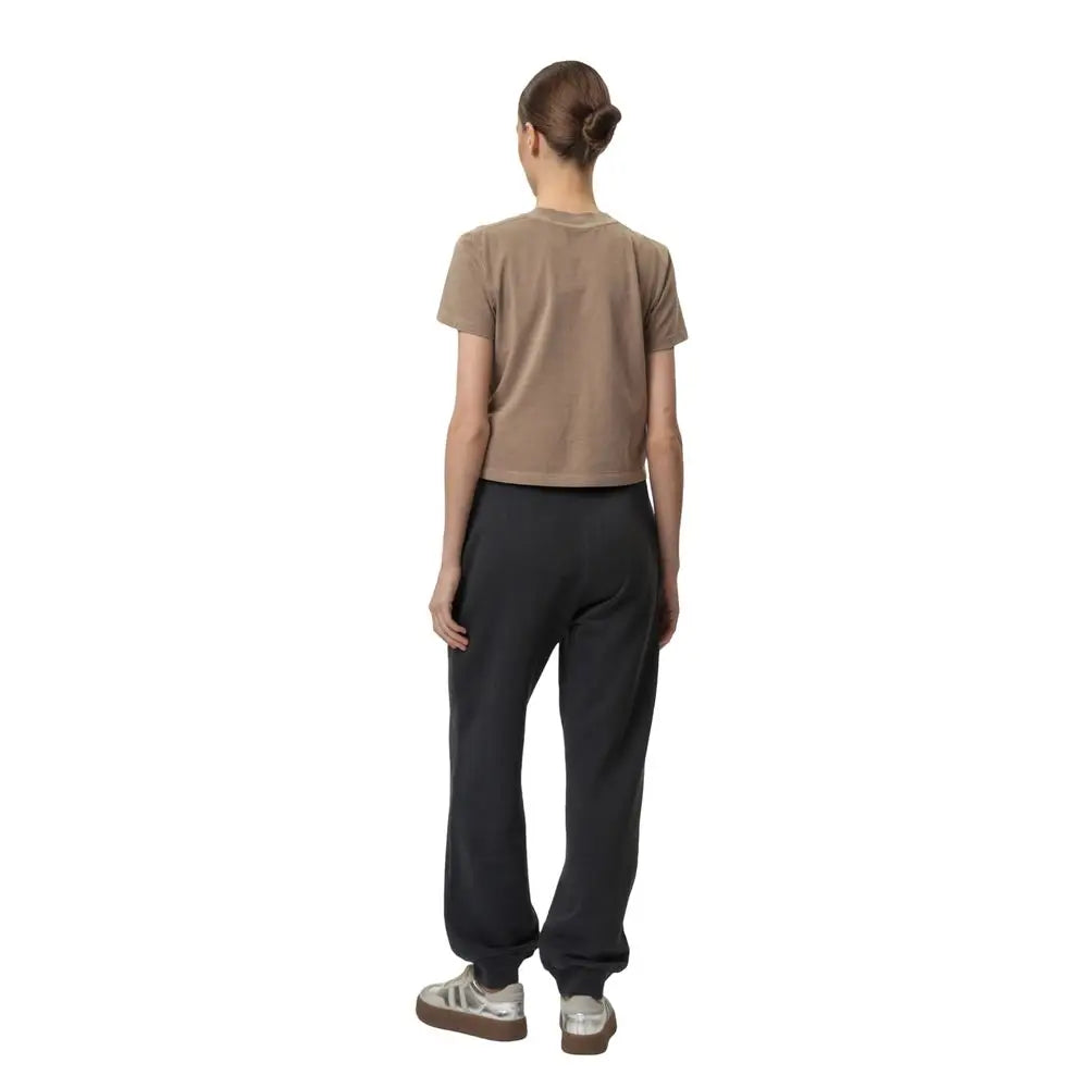 Une femme porte un t-shirt beige manches courtes avec un jogger gris en coton calvin klein jeans pour le sport