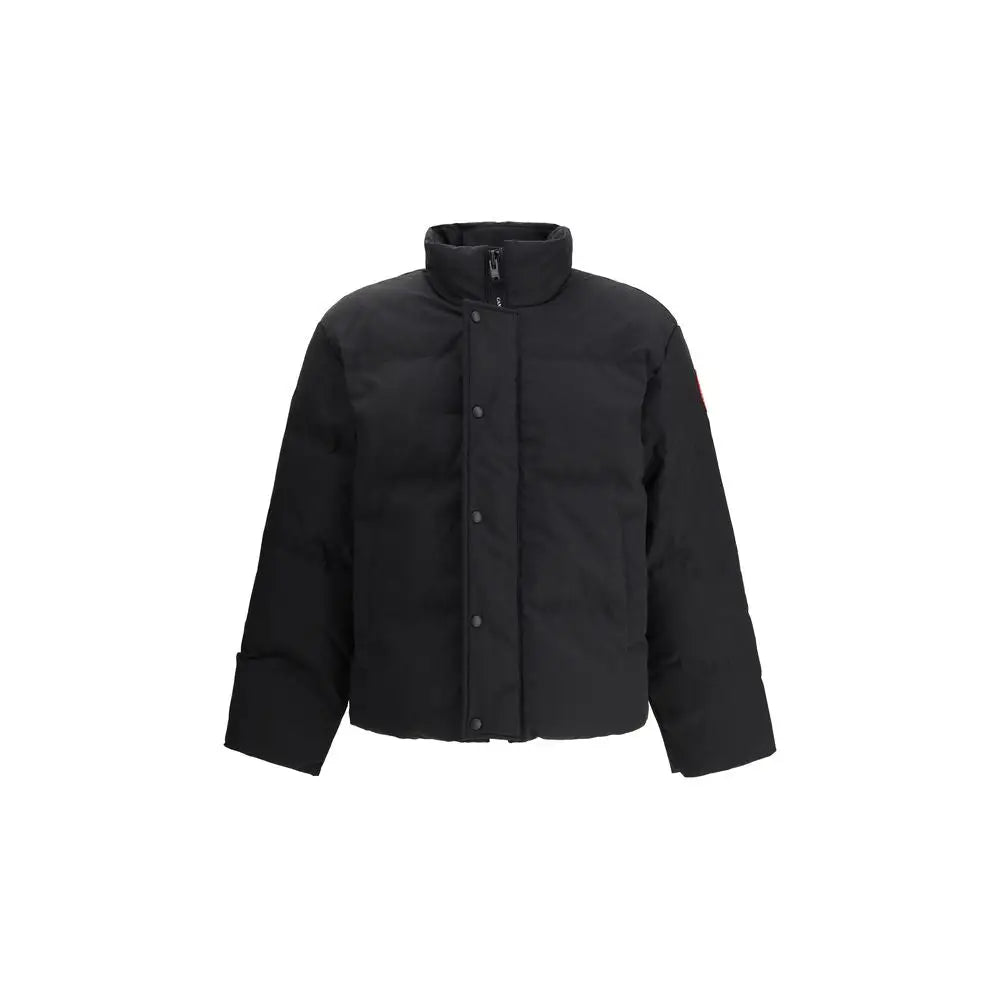 Parka canada goose noire en polyester avec col haut, fermeture boutonnée et logo rouge discret sur la manche gauche