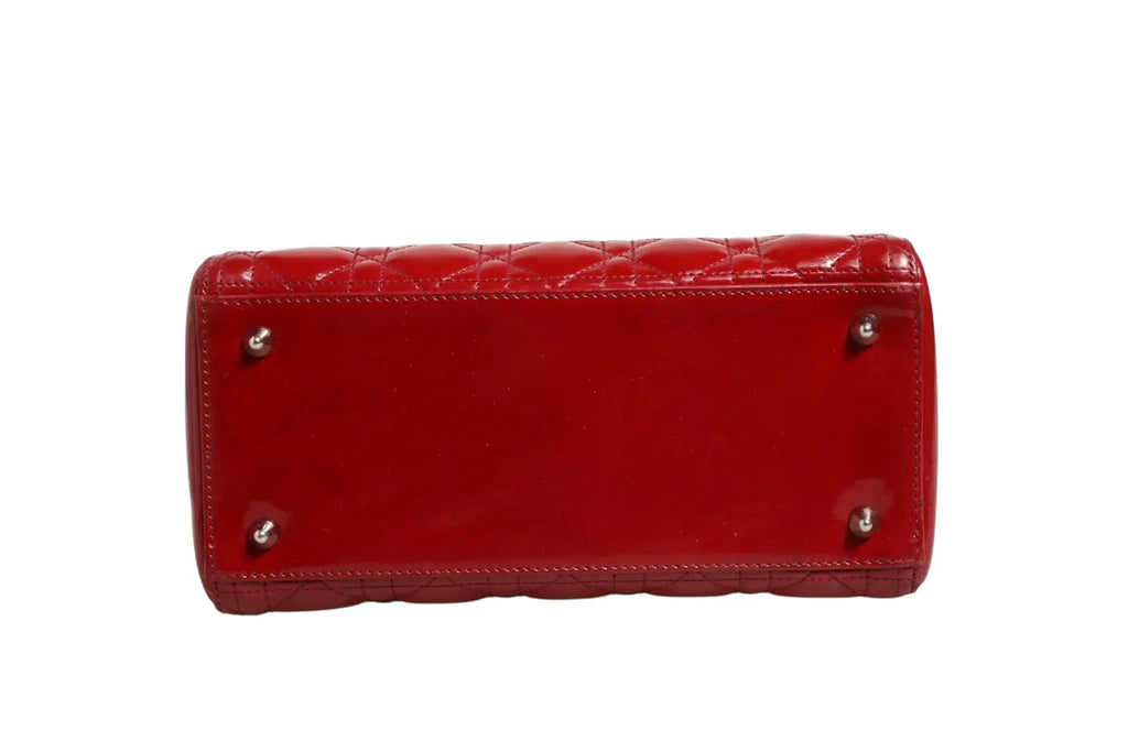 Sac lady dior petit modèle en cuir verni rouge cerise avec matelassage cannage et garnitures argentées