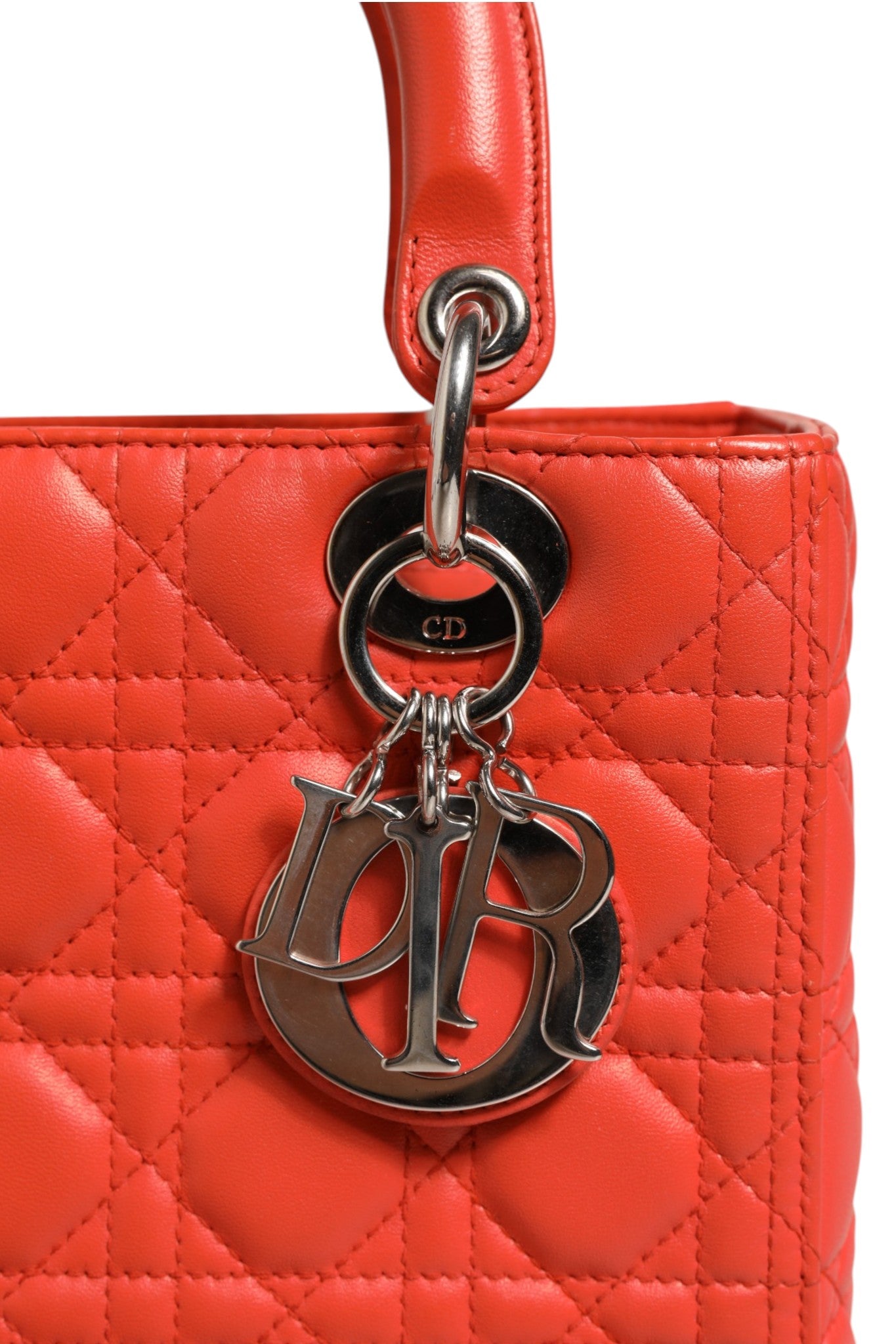 Sac à main Lady Dior en cuir de veau orange avec motif cannage de Christian Dior, élégant et sophistiqué.