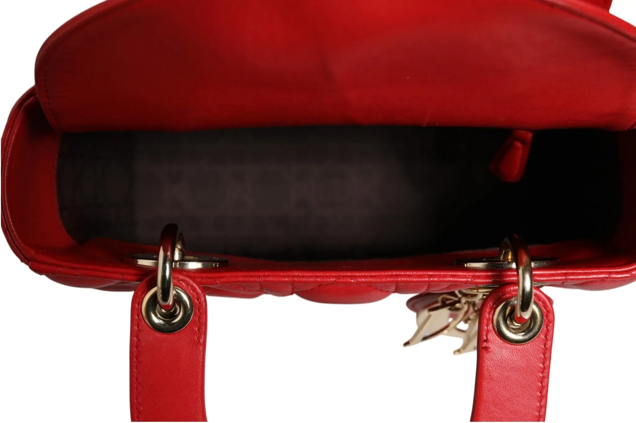 Sac à main christian dior lady dior en cuir matelassé rouge avec ferrures dorées et breloque suspendue