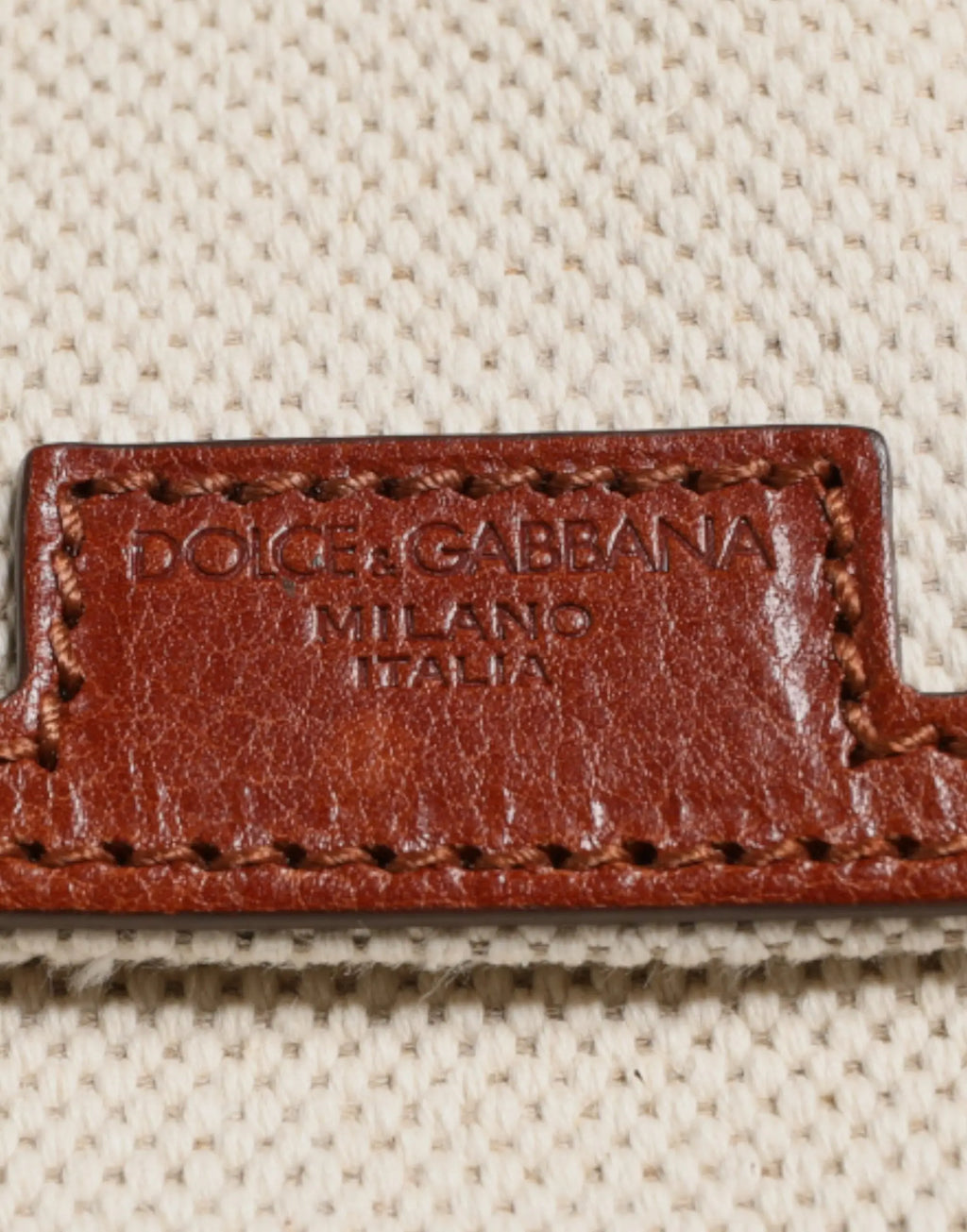 Étiquette en cuir marron embossée dolce gabbana milano italia sur sac à dos voyage beige marron en toile et cuir homme edge