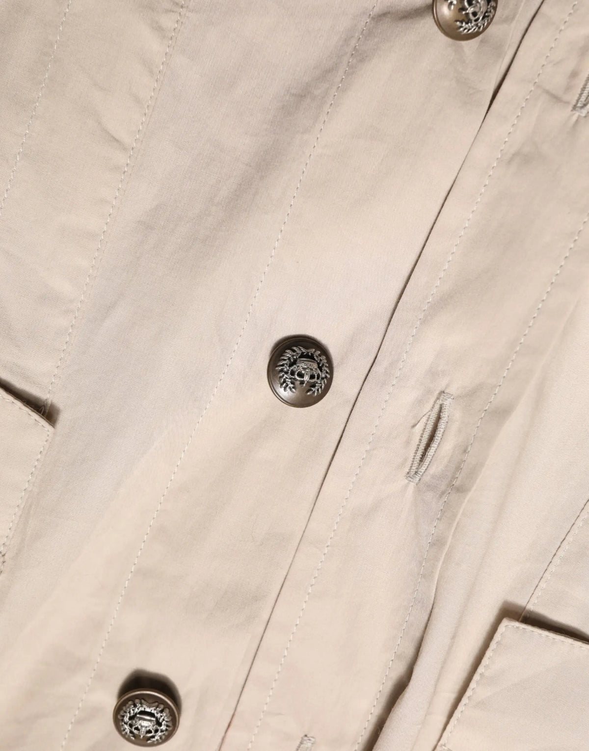 Manteau trench beige avec boutons argentés gravés de motifs floraux et crânes signé dolce gabbana