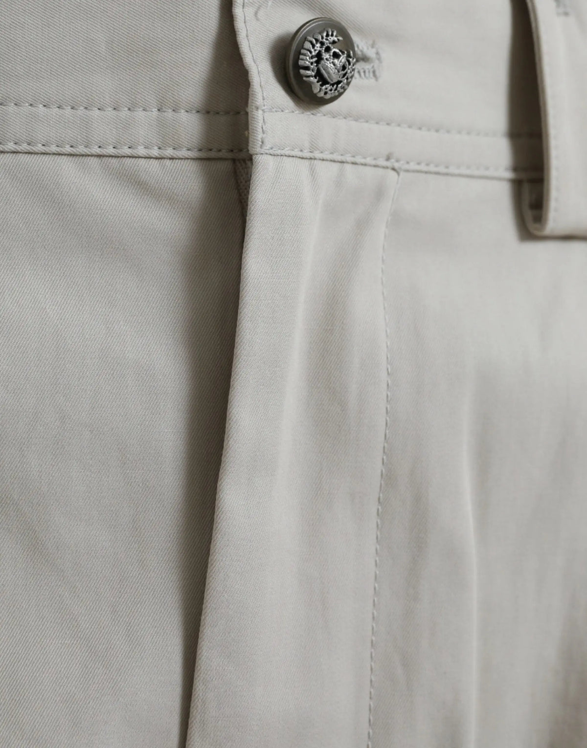 Bouton en forme de crâne argenté détaillé sur la taille du pantalon beige en coton dolce gabbana à taille haute