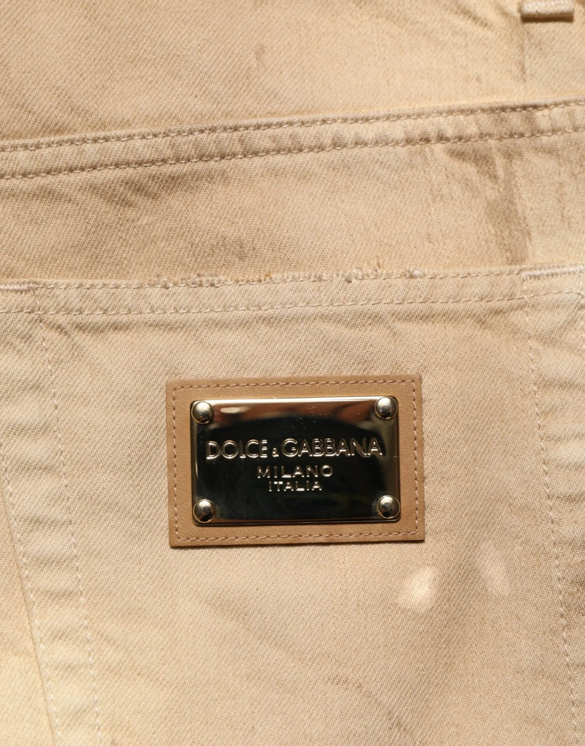 Jeans beige en denim coton pour homme dolce gabbana avec patch rectangulaire en cuir et clous métal argenté à l arrière