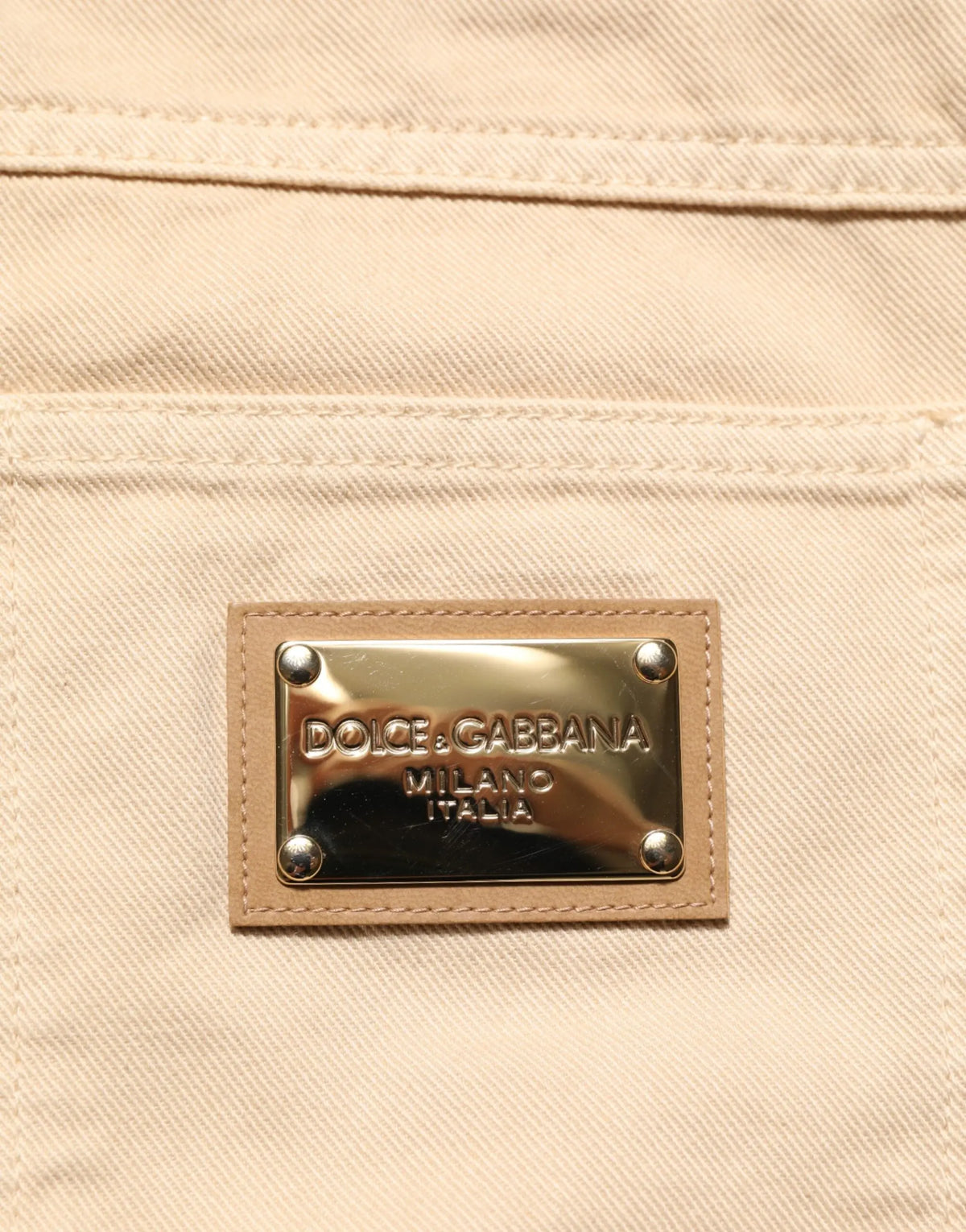 Beige denim jeans en coton homme dolce gabbana avec plaque métallique dorée et rivets argentés au dos