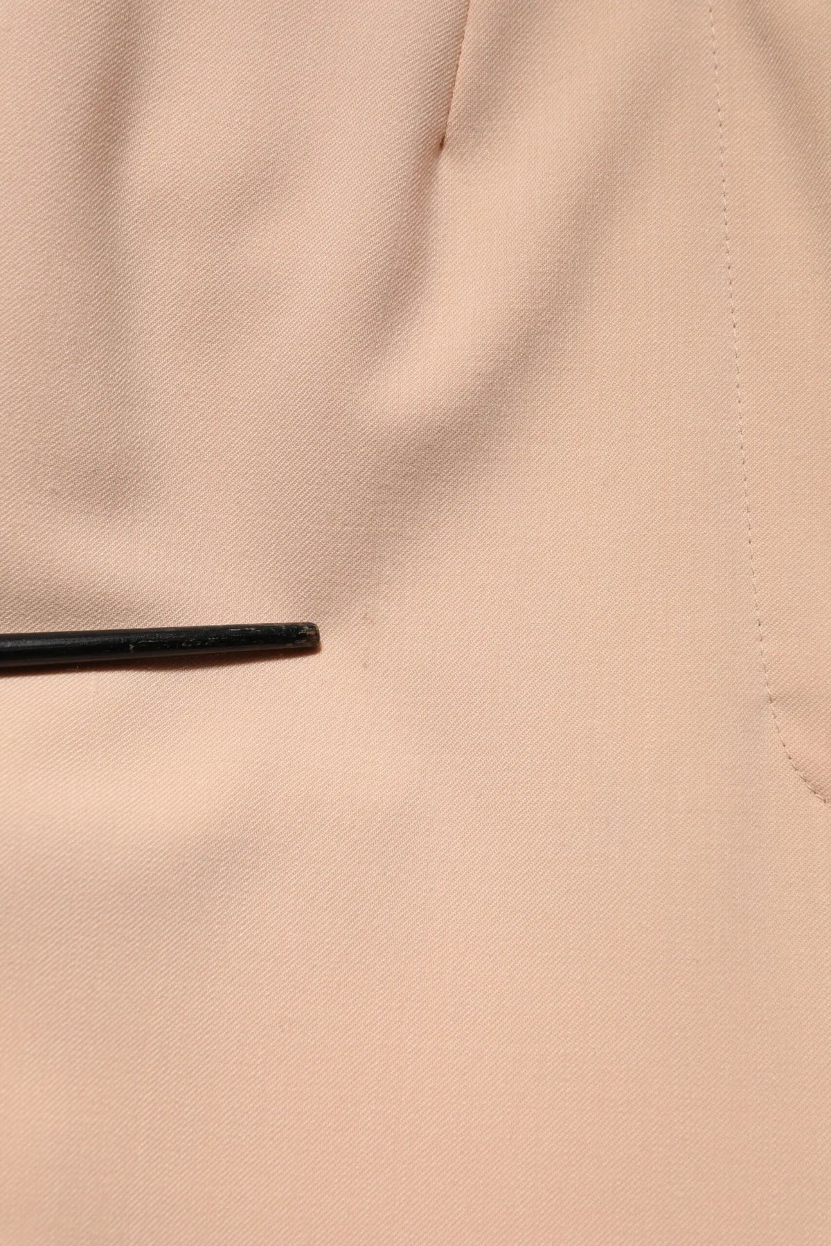 Un stylo noir mince posé sur un tissu pêche douce avec un pantalon beige en polyester dolce & gabbana taille moyenne tapered