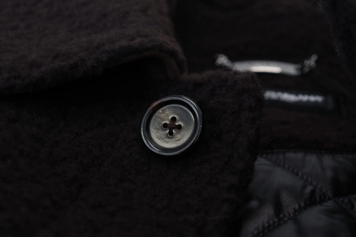 Bouton rond argenté avec une indentation en croix sur tissu brun foncé pour trench coat dolce gabbana en alpaga noir