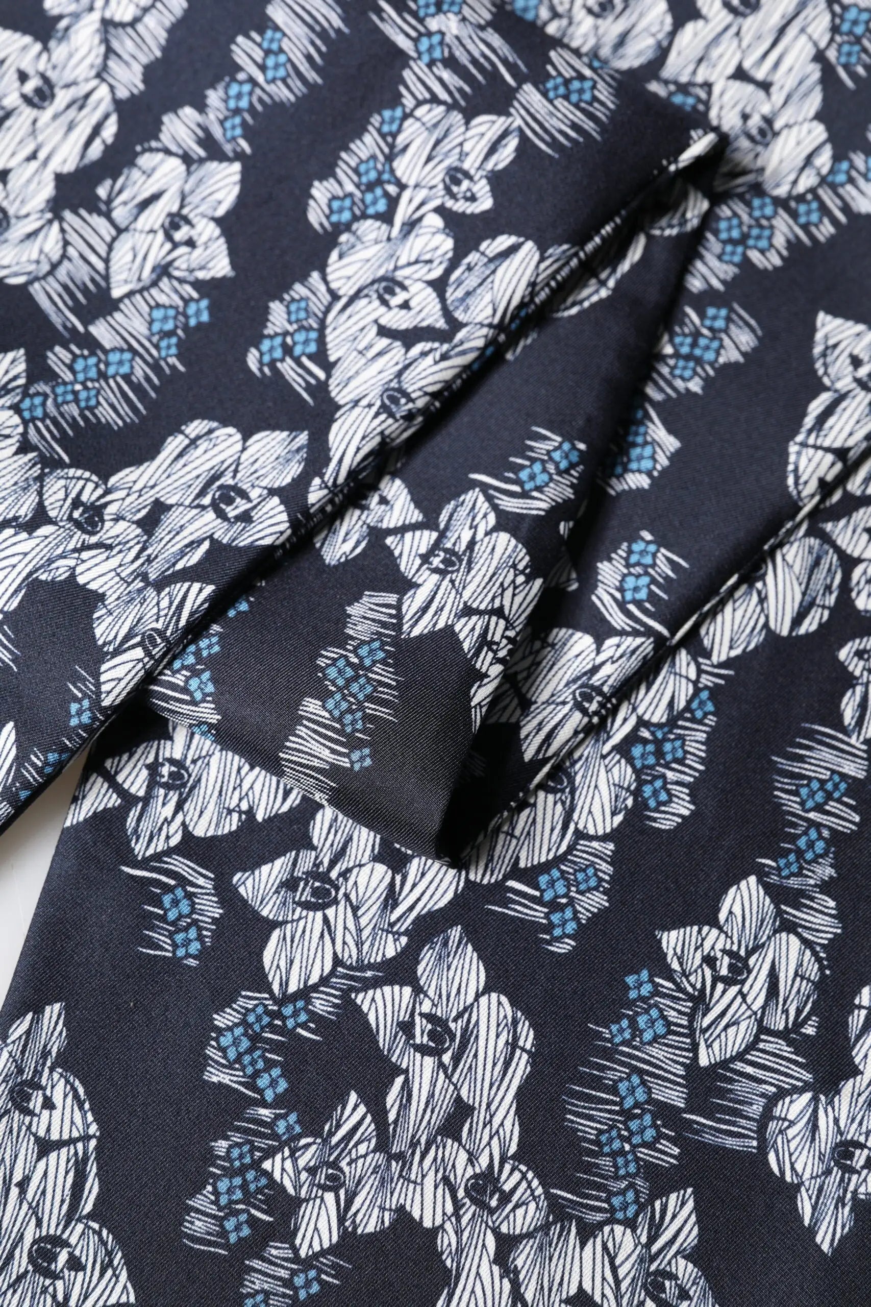 Foulard dolce & gabbana en soie noire et bleue marine avec motif floral stylisé blanc et bleu clair frangé 140cm x 16cm