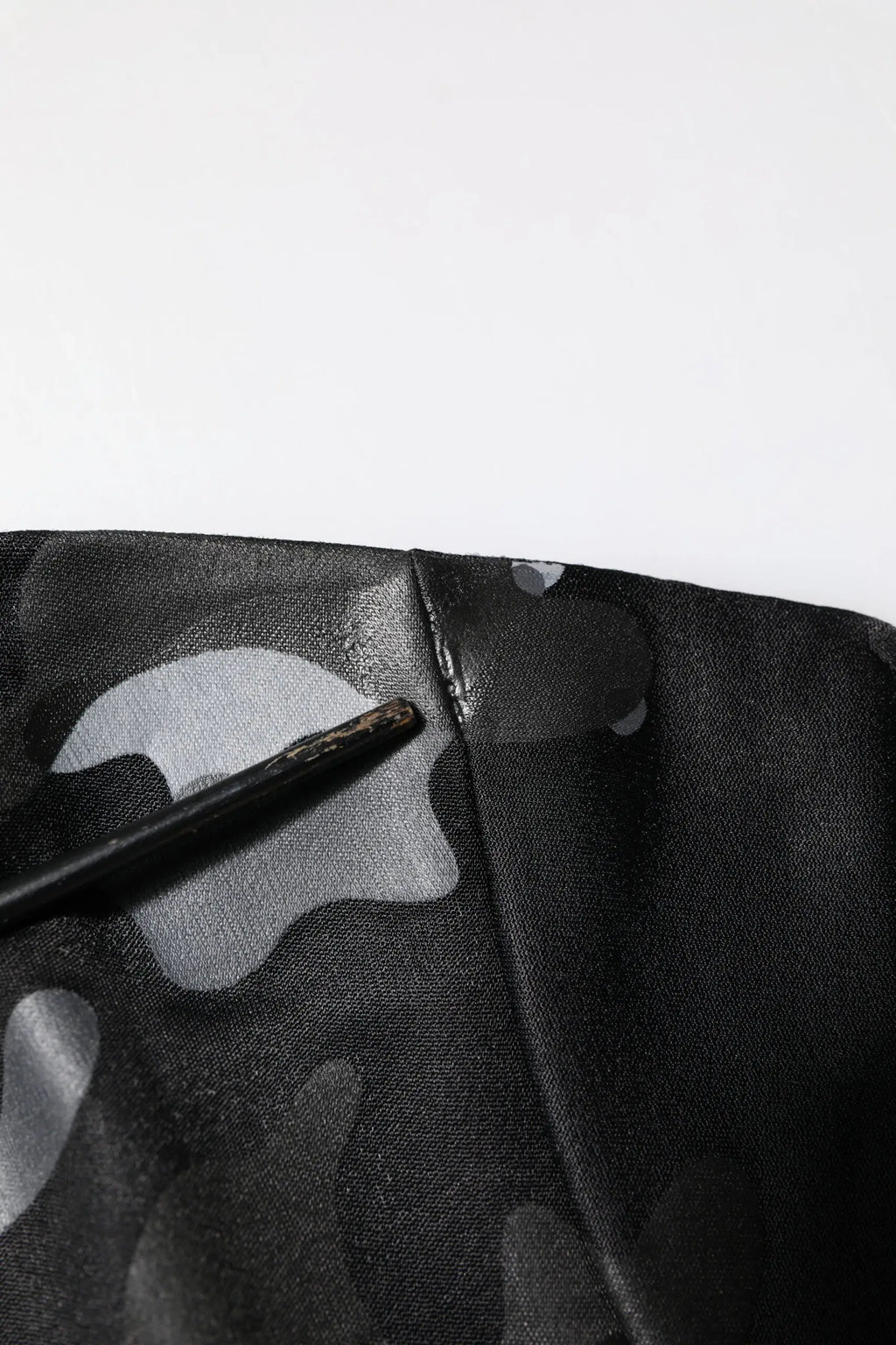 Pull over dolce & gabbana noir avec motif camouflage gris subtil en tissu et outil noir posé sur une couture