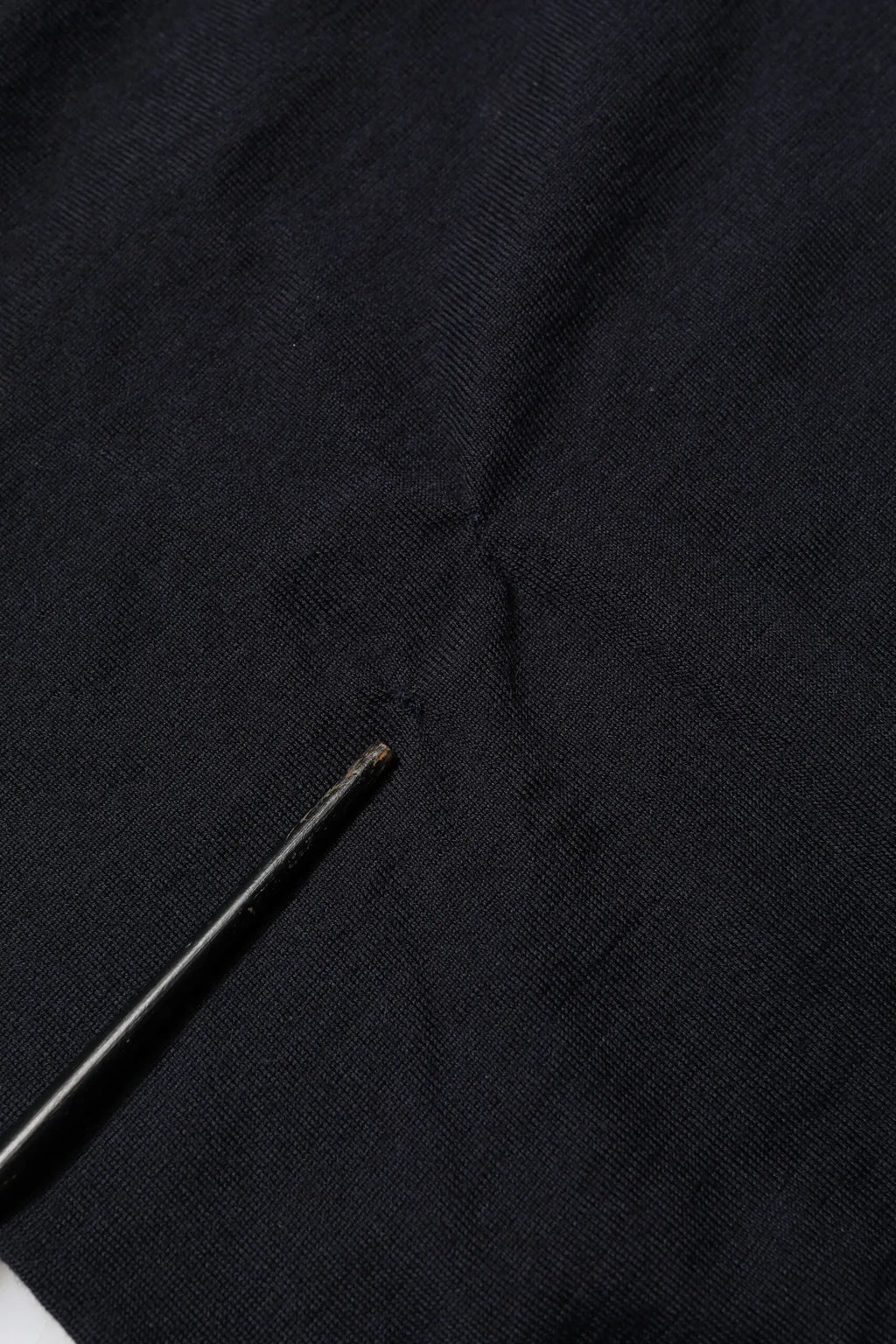 Étoffe noire texturée en cachemire avec une petite aiguille métallique sur un pull dolce & gabbana col v