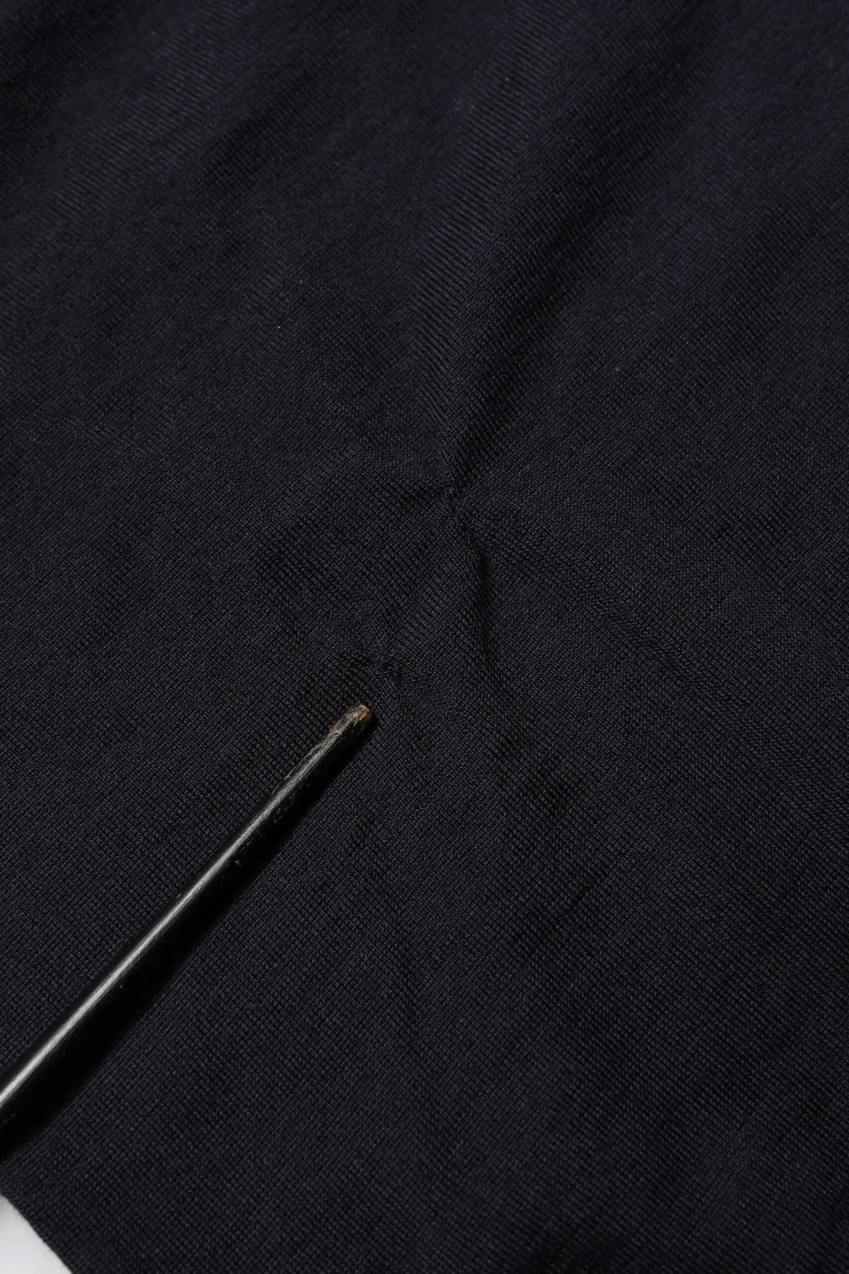 Étoffe noire texturée en cachemire avec une petite aiguille métallique sur un pull dolce & gabbana col v